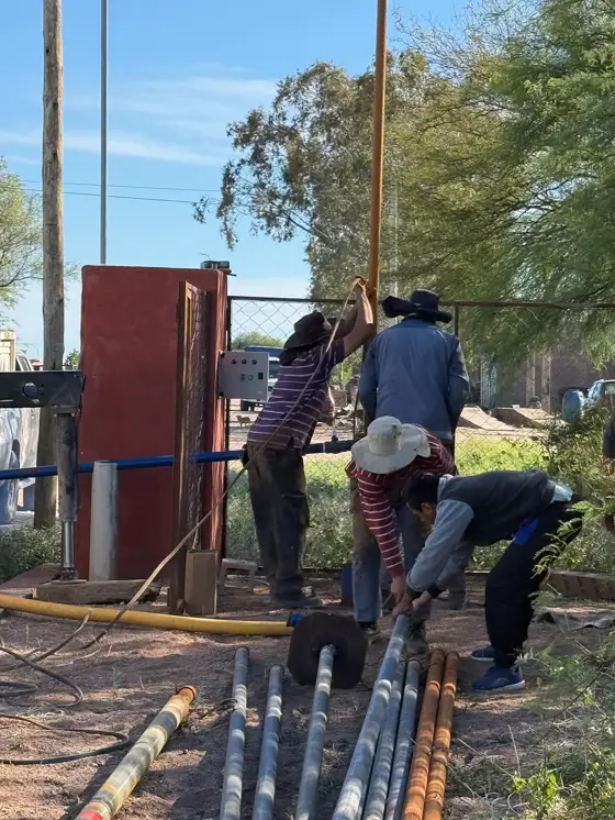 Cuadrilla desarmando la columna de bombeo junto a la perforación